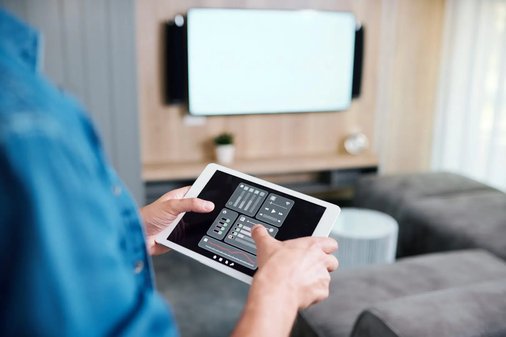 Person using a tablet with a smart home control app.