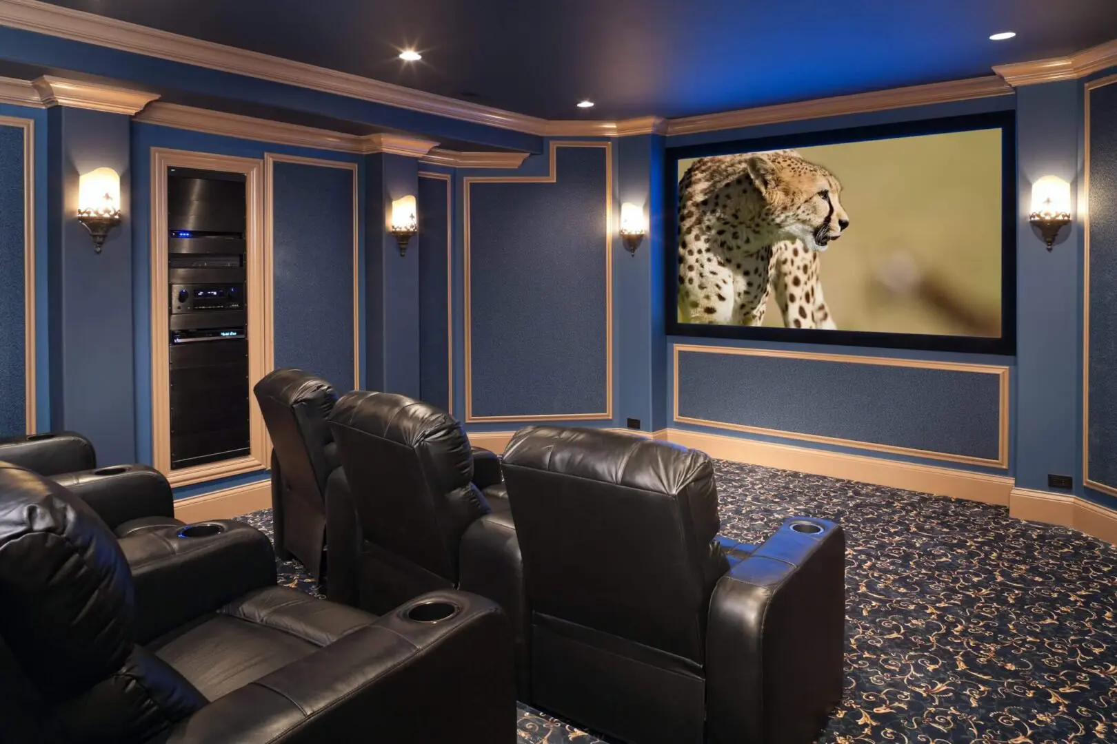 Cozy home theater with leather seats and a leopard on the screen.