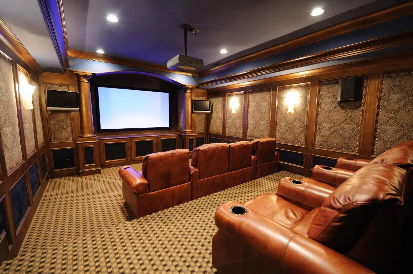 Luxurious home theater with leather recliners and large screen.