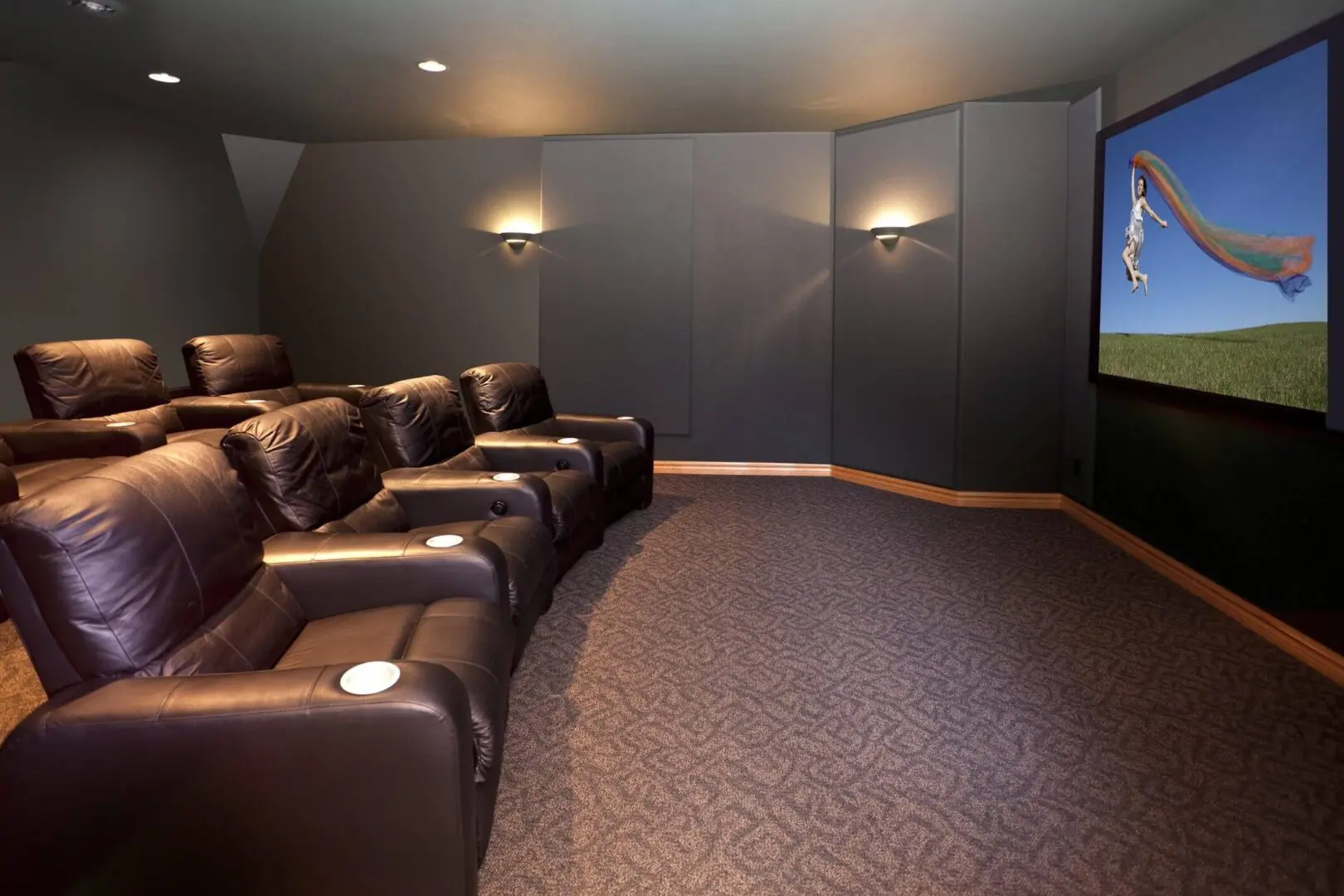 Cozy home theater with reclining leather seats and dim wall lights.