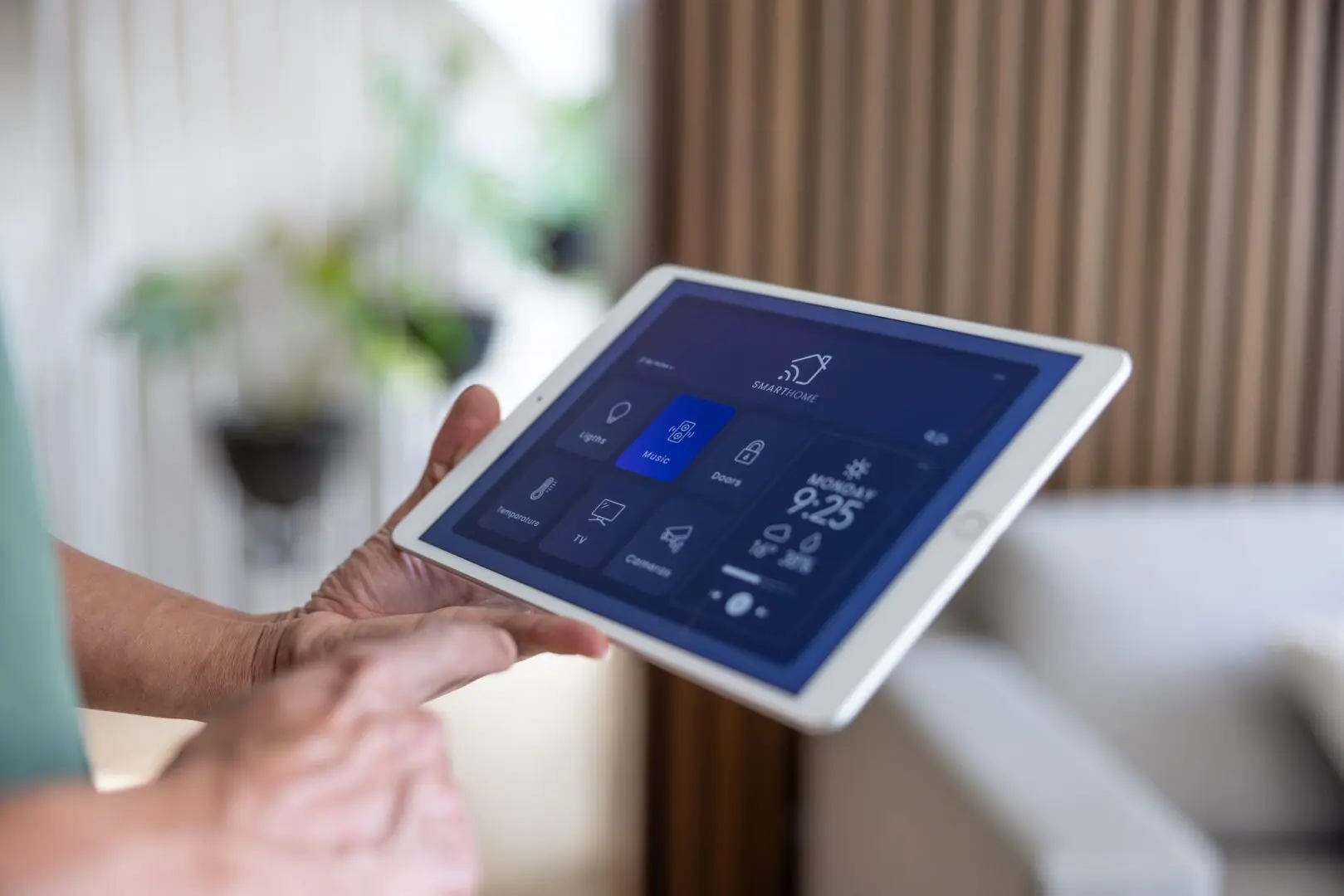 Hand adjusting smart home thermostat on a tablet.