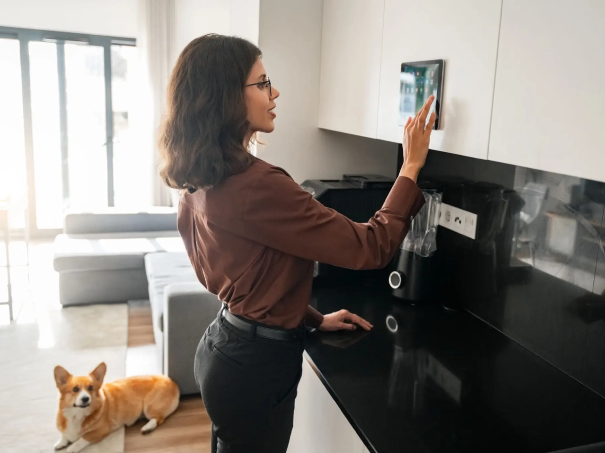 Woman using smart panel in kitchen.
