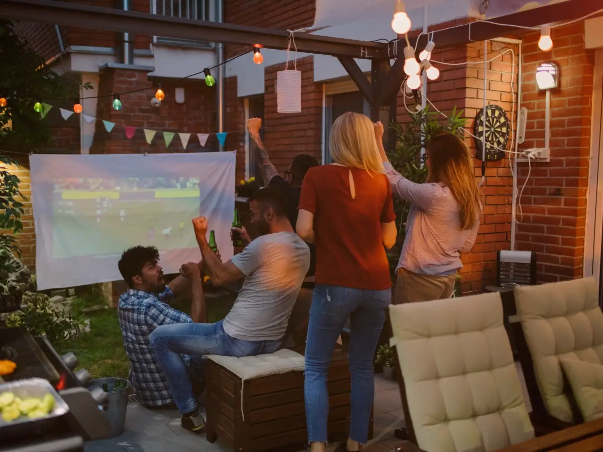 Backyard party with friends watching sports.