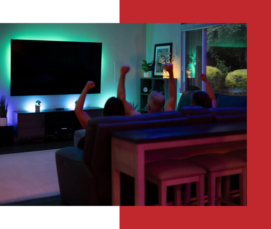 People cheering while watching TV at home.