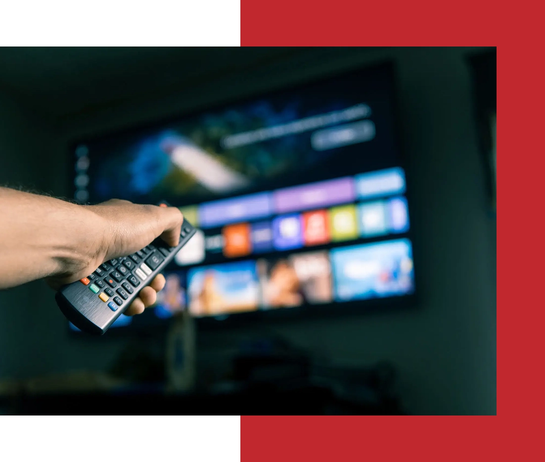 Hand holding remote, pointing at smart TV.